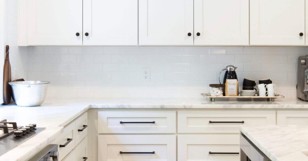 Cabinets in the corner of a white kitchen.