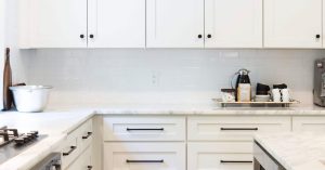 Cabinets in the corner of a white kitchen.