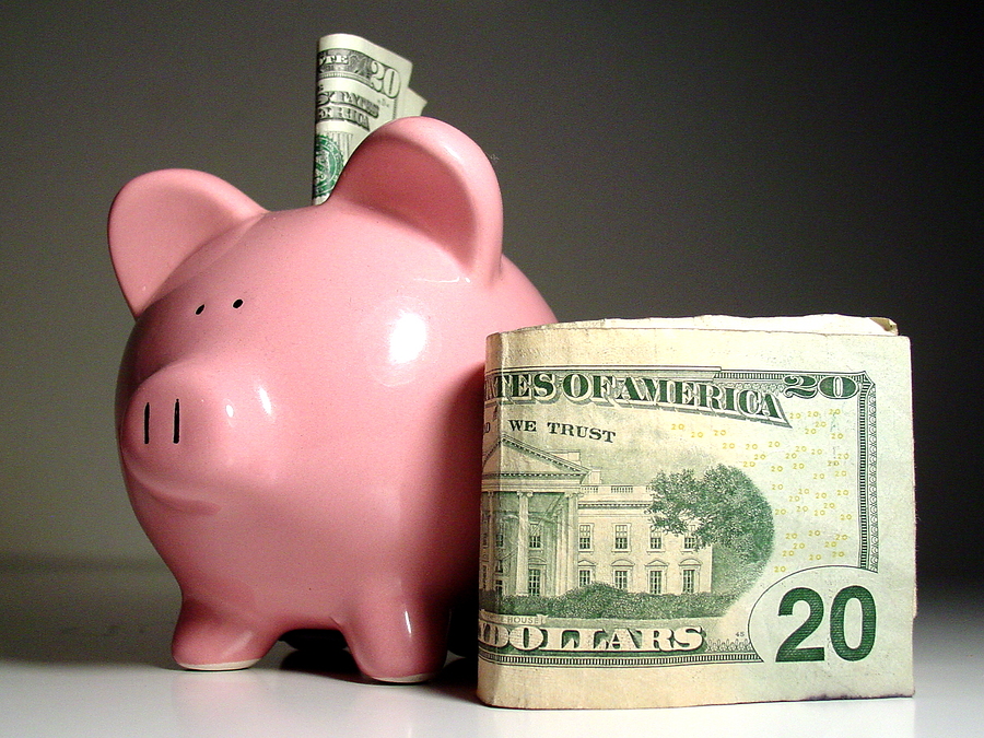 Piggy bank with money beside it.