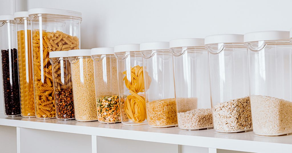 Clear plastic storage containers on a shelf in the pantry help you keep your kitchen organized.