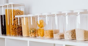 Clear plastic storage containers on a shelf in the pantry help you keep your kitchen organized.