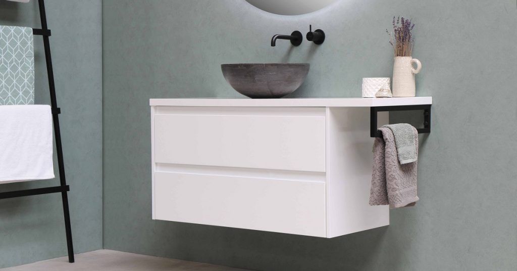 Small white bathroom vanity with flat front drawers.