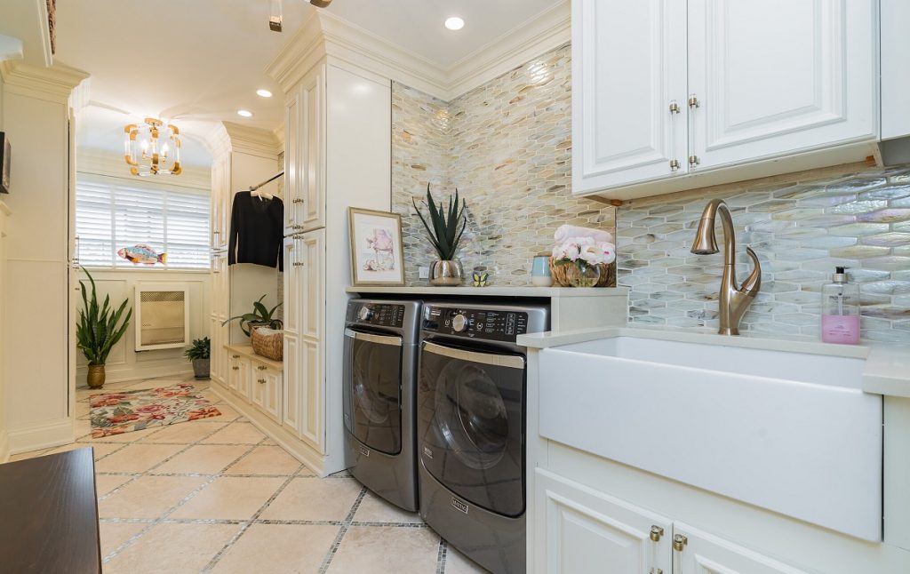 Large laundry room with cabinets and hanging rod.