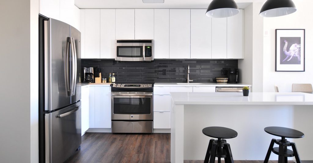 Dark wood floors with white cabinets and black accents.