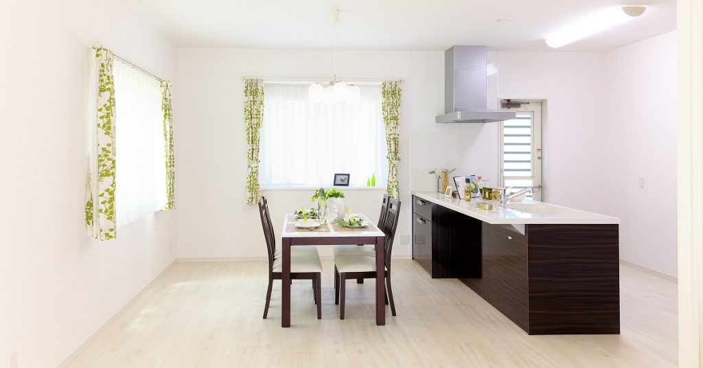 Open format kitchen and dining with dark walnut frameless cabinets in the galley kitchen.