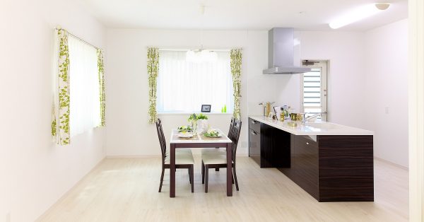 Open format kitchen and dining with dark walnut frameless cabinets in the galley kitchen.