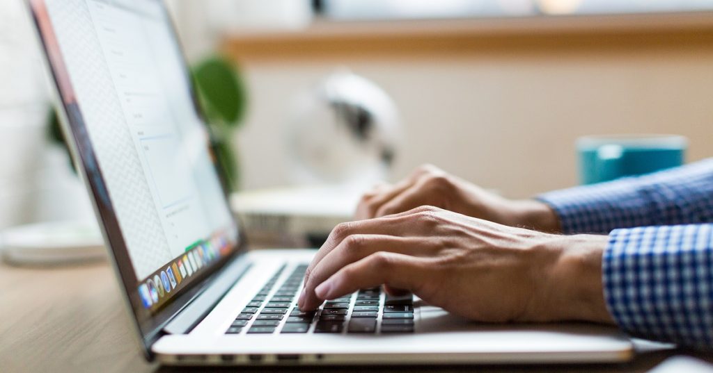 Person's hands on a laptop keyboard.
