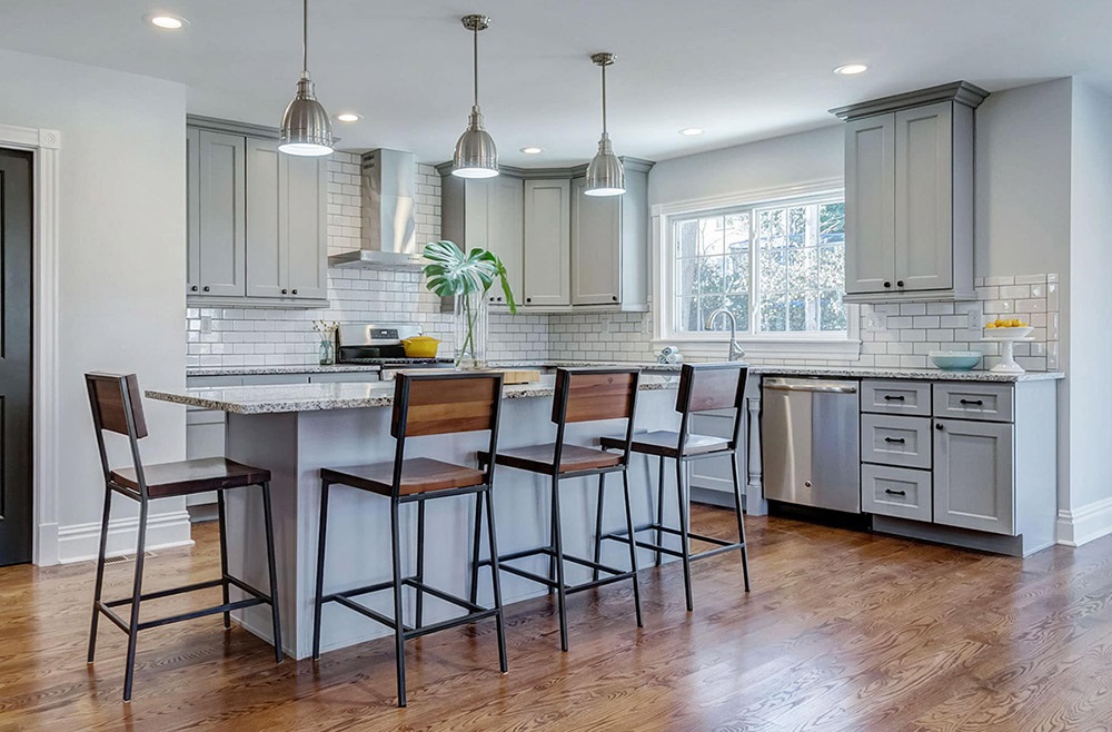 Gray cabinets in a neutral kitchen with warm wood accents.