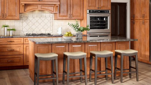 Kitchen with traditional wood cabinets and a tile backsplash with island in the foreground.