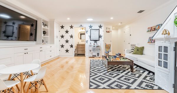 Living room with wood floors and black and white geometric rug.