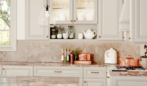 Neutral kitchen with lighted glass front cabinets and long brass handles.