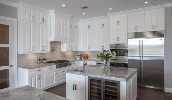 Large kitchen with white cabinets and gray countertops.