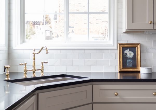 Kitchen with greige cabinetry and a corner sink.