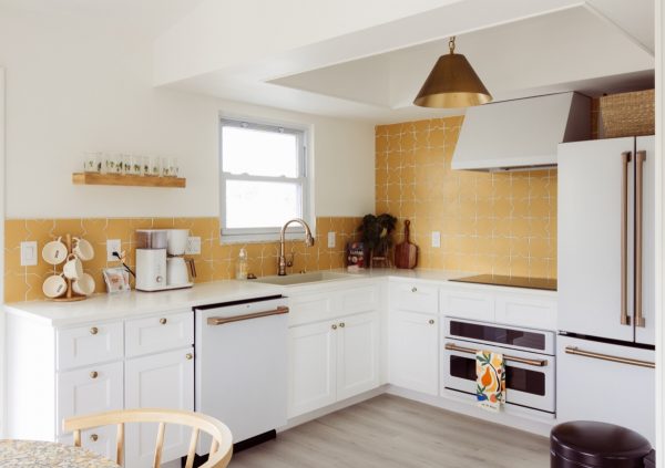 White and yellow kitchen featuring Shaker cabinet style and wood floors.