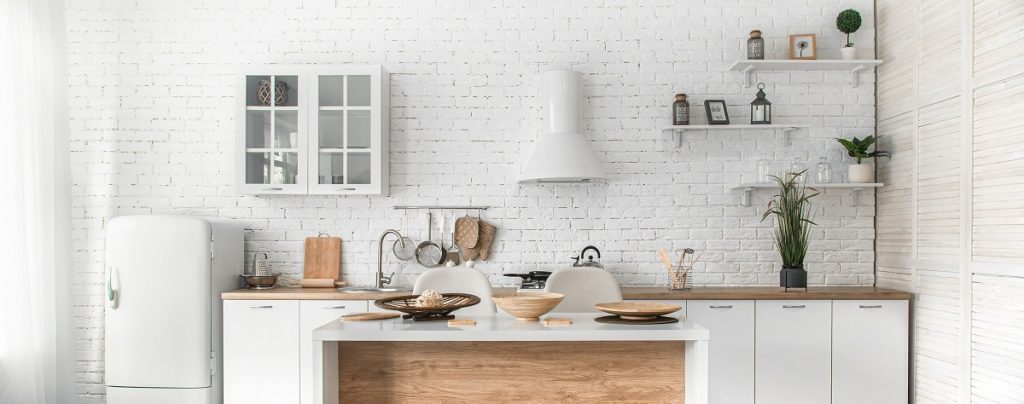 White kitchen with natural wood island and glass front cabinets.