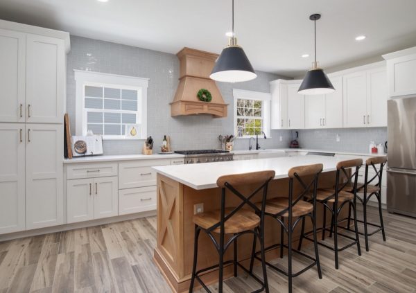 Sand colored Shaker cabients in a large neutral kitchen with black accents.