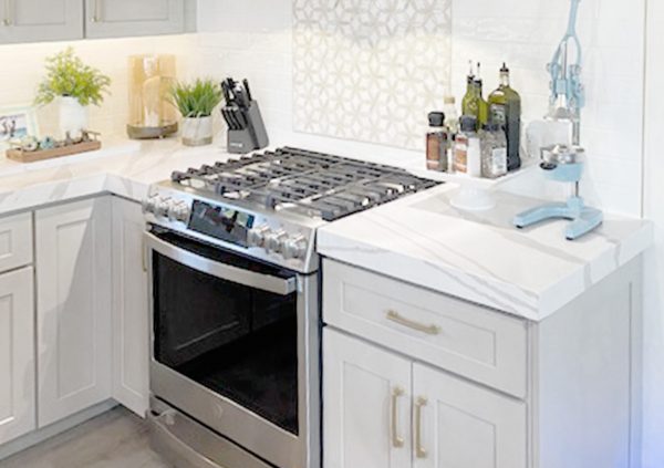 White kitchen with Shaker cabinets and long slim handles with tile backsplash.