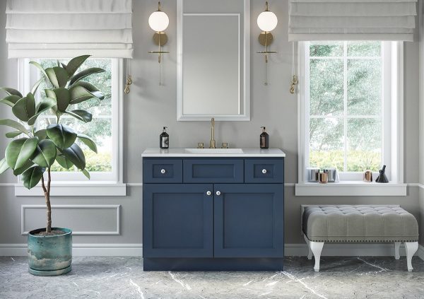 Large bathroom with blue vanity and mirror flanked by sconces.