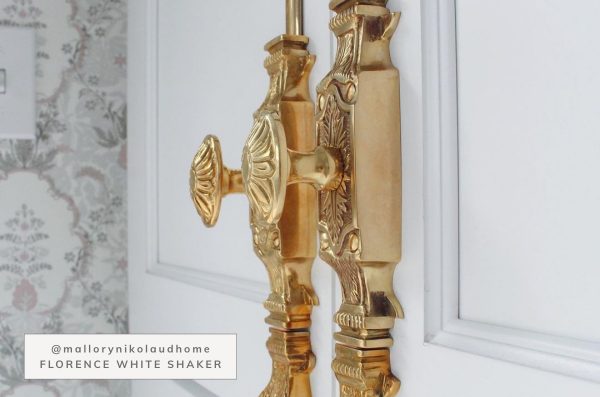 Close up of gold cabinet pulls with white cabinets.