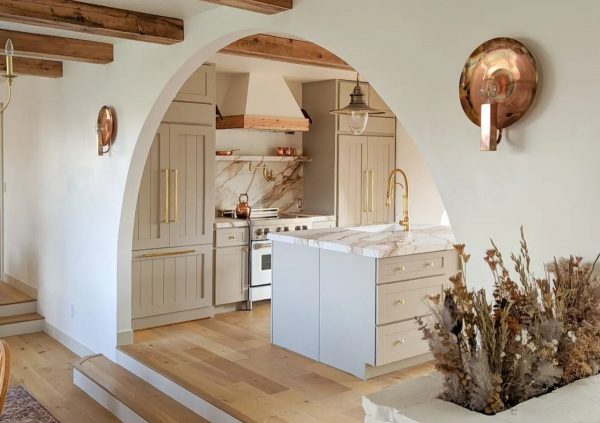 Provincial style kitchen with Shaker cabinets and light wood floor.