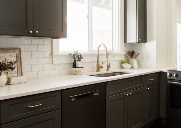 Dark Shaker cabinets with white countertop and window above kitchen sink.
