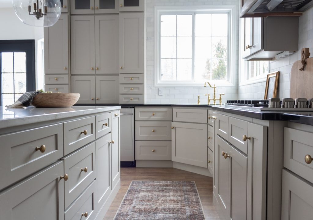 White Shaker cabinets in a cozy kitchen with big windows.