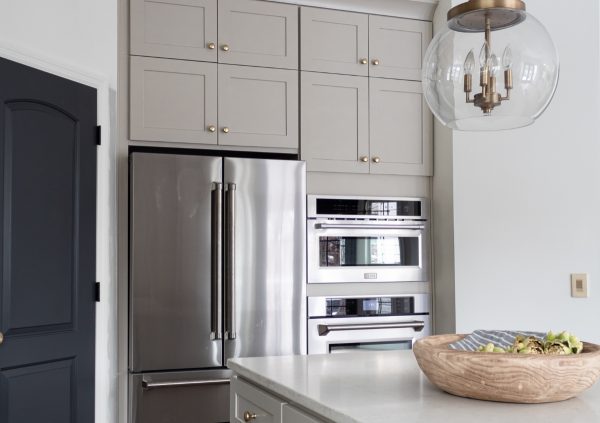Greige shaker cabinets that reach all the way to the ceiling.