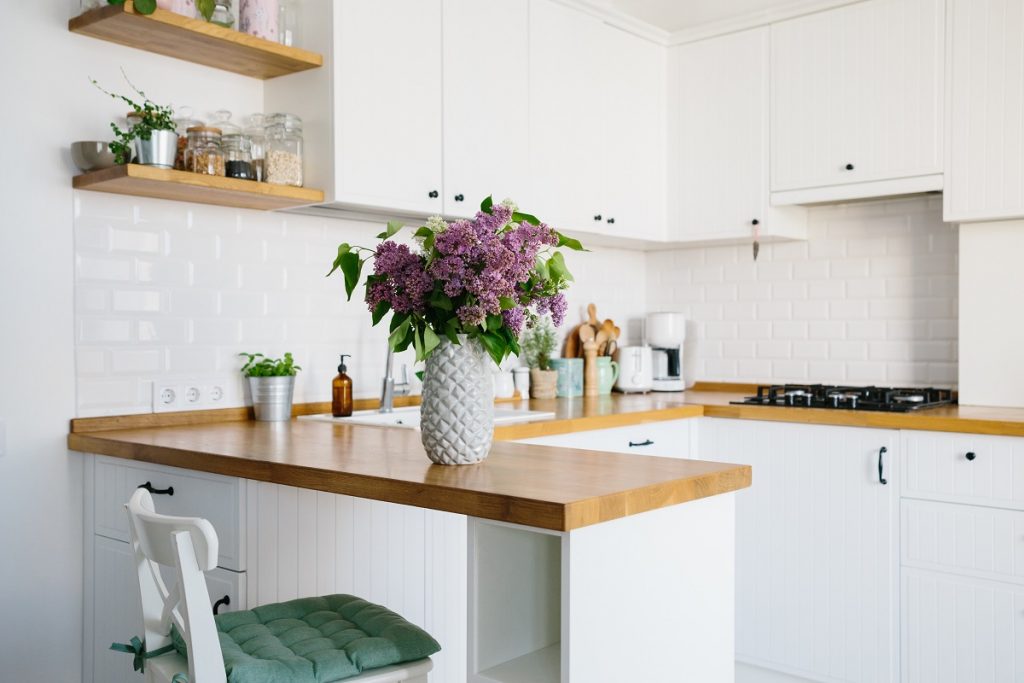 White kitchen with wood countertops and open shelving.