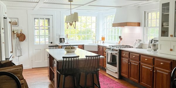 A modern farmhouse kitchen with wood cabinets and white walls.